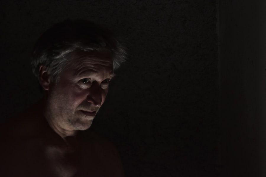 Homem grisalho em luz baixa, olhando de lado